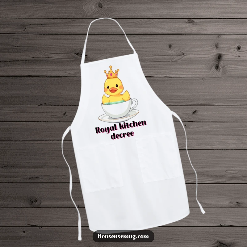 Funny crowned rubber duck floating in a teacup on a kitchen apron.
