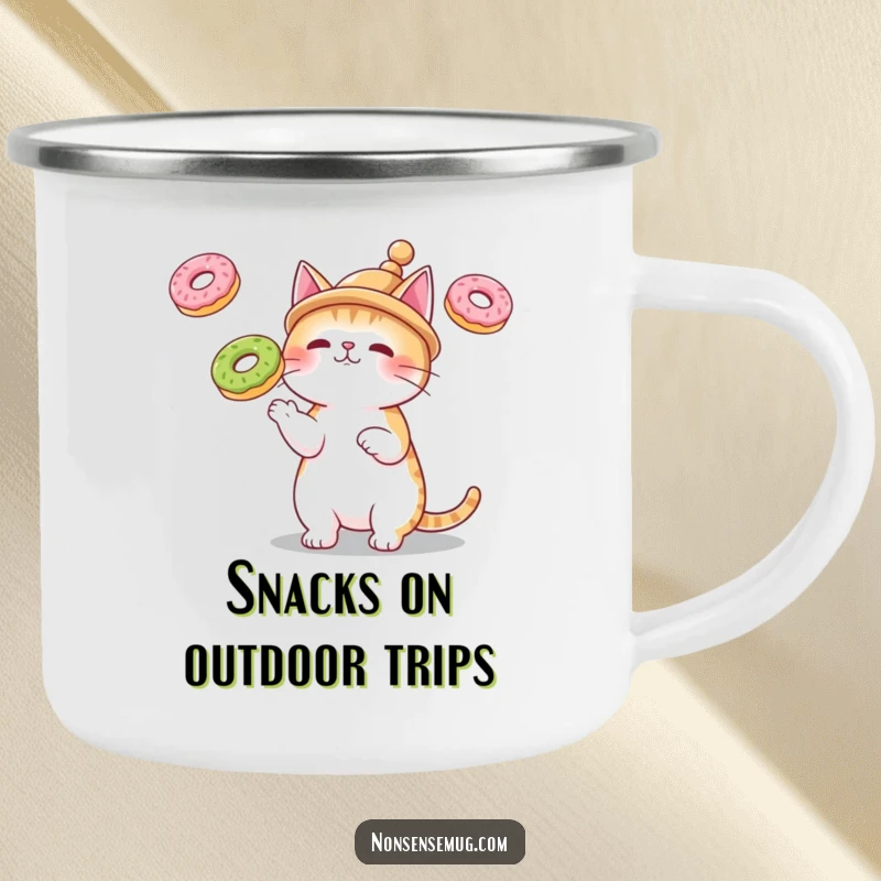 Funny camping mug featuring a cat in a tiny hat, juggling three floating donuts, for humorous outdoor enjoyment.