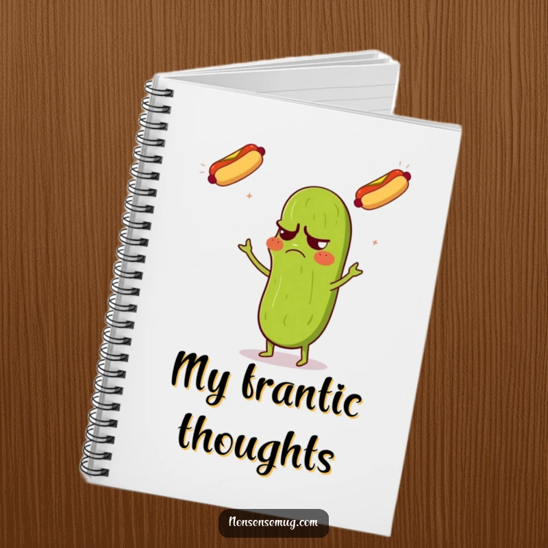Funny notebook featuring a grumpy pickle looking confused while juggling three flying hot dogs, with lined pages.