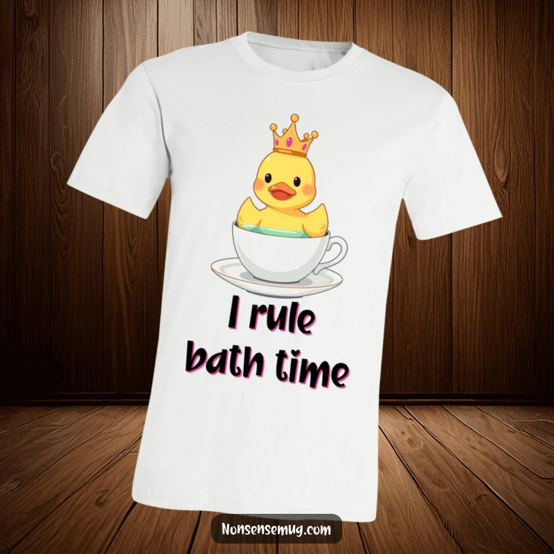 Funny rubber duck with a small crown, floating in a teacup, featured on a quirky t-shirt.