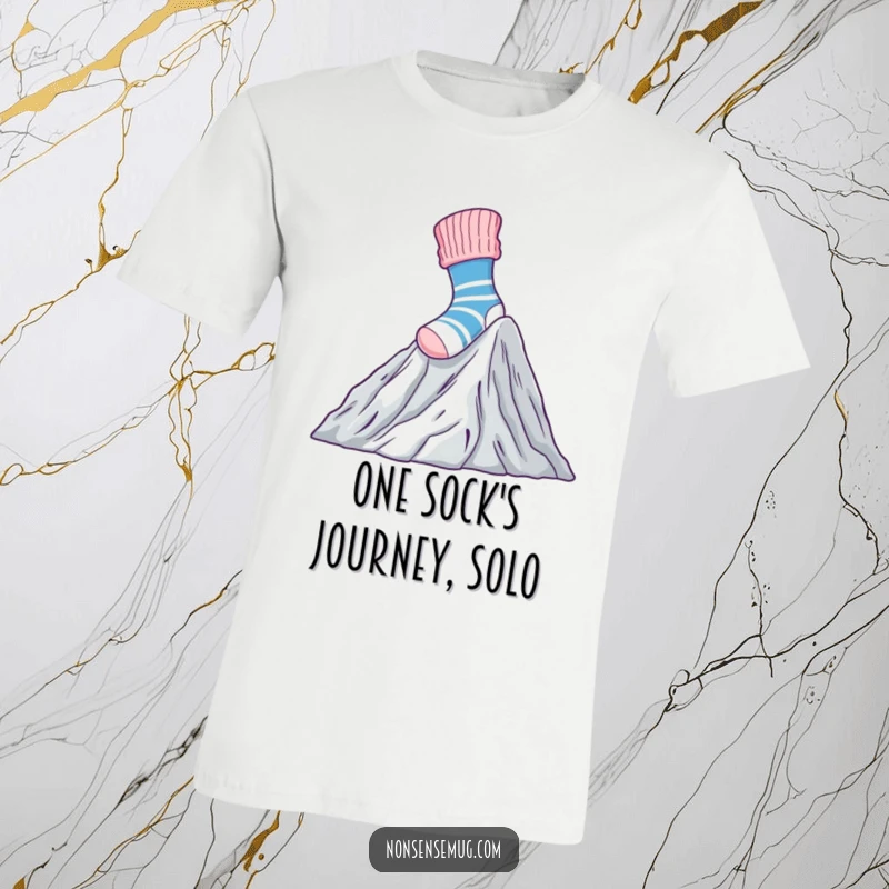 Funny T-Shirt with a brave sock climbing a huge mountain of laundry, representing the epic struggle of chores.