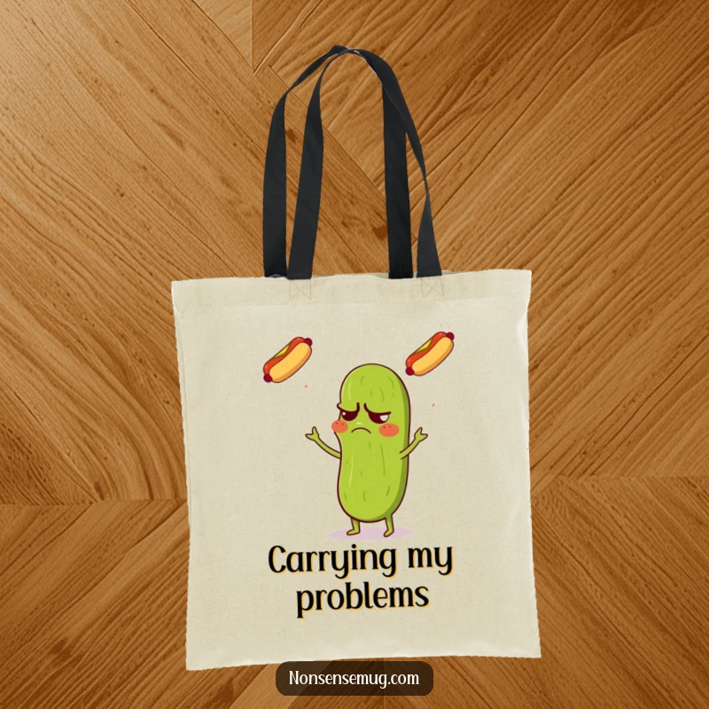 Funny tote bag featuring a grumpy pickle with a confused expression, juggling three flying hot dogs with comedic skill.